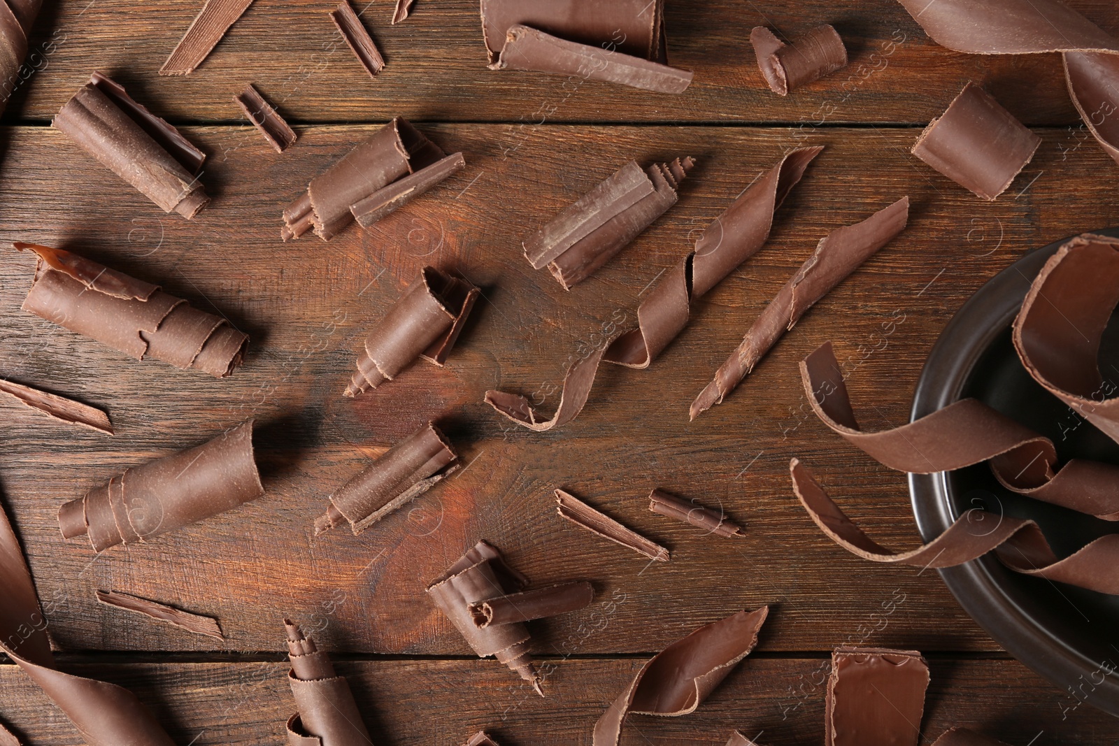 Photo of Flat lay composition with chocolate curls on wooden background