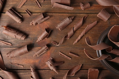 Flat lay composition with chocolate curls on wooden background