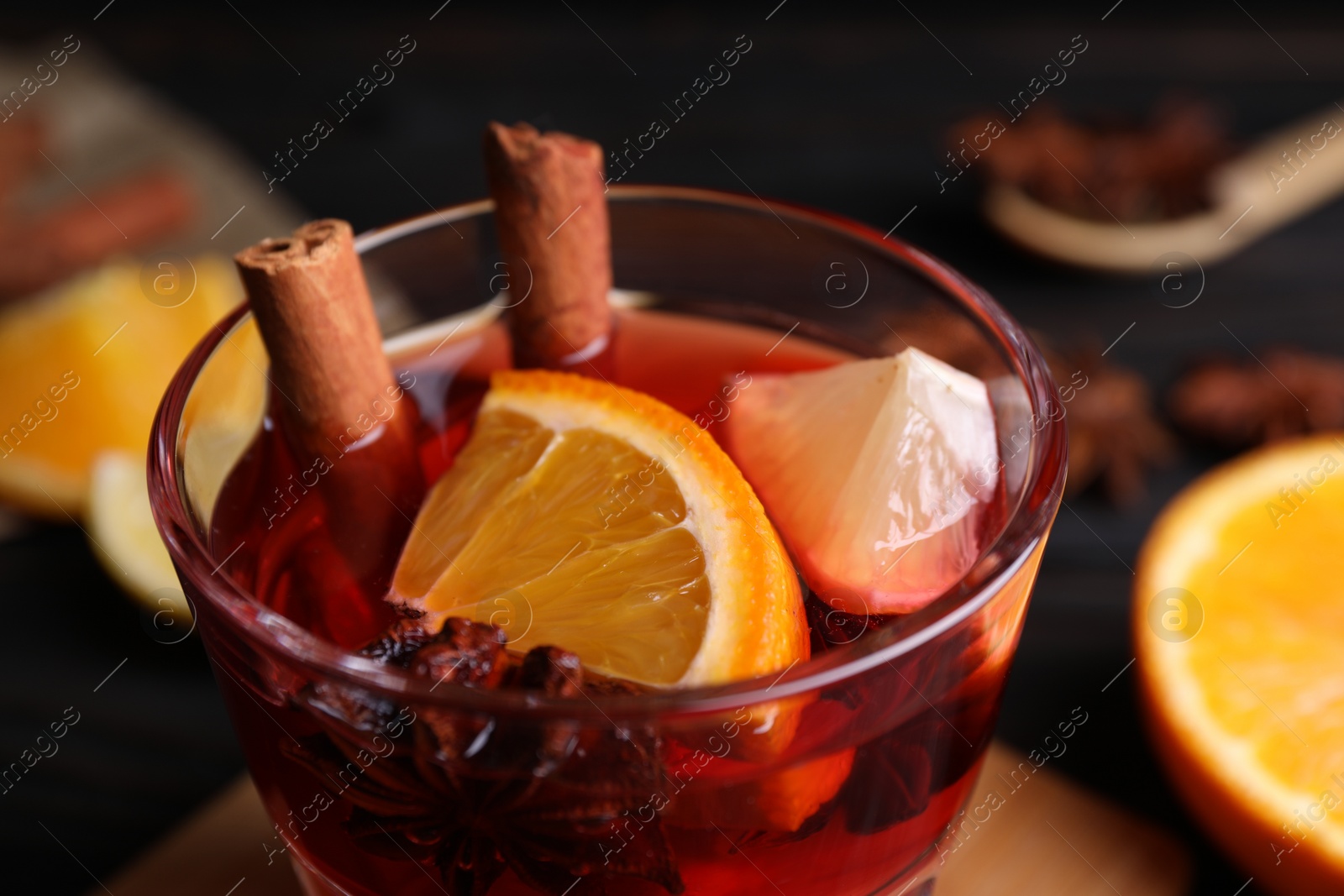 Photo of Glass of aromatic punch drink on table, closeup