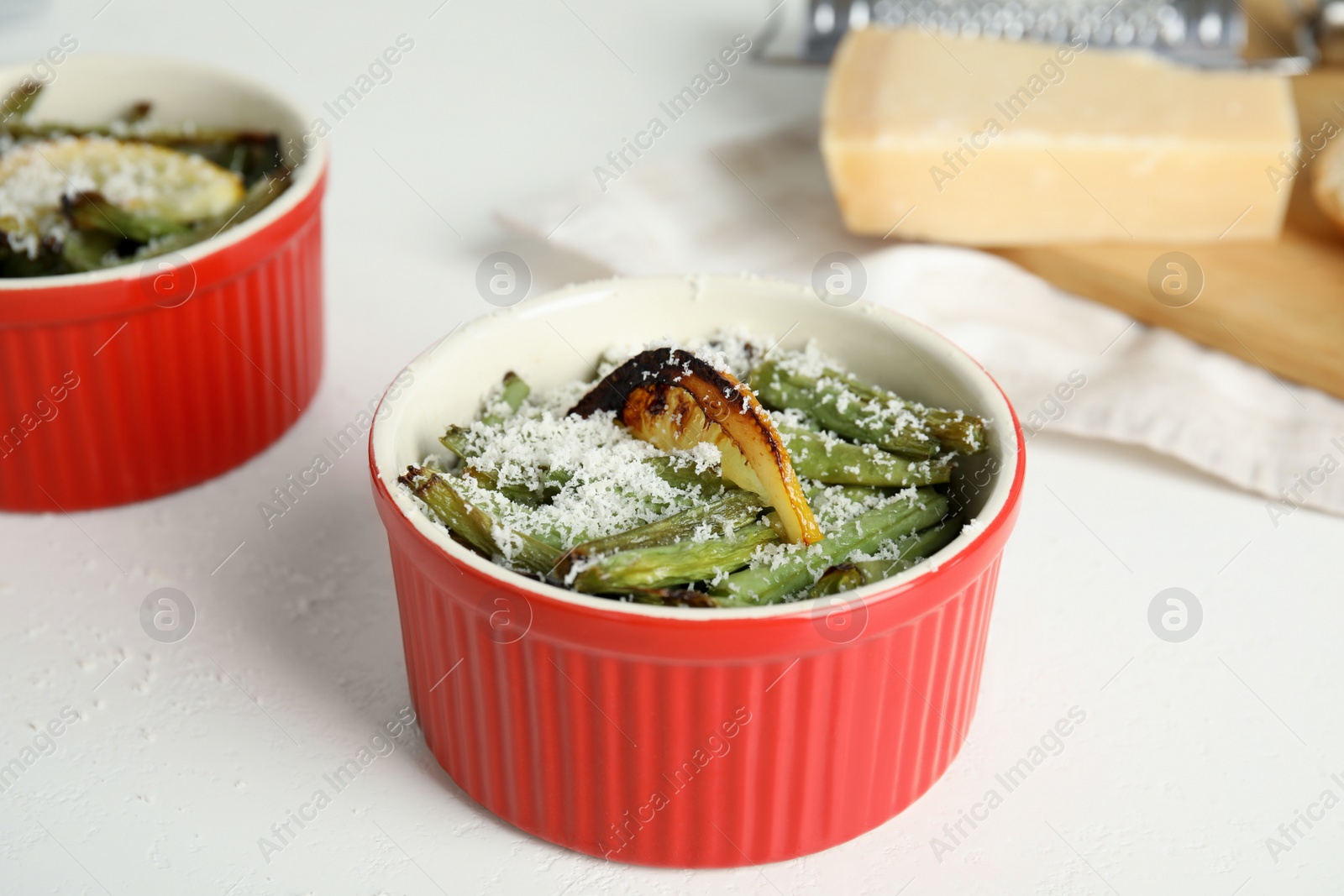 Photo of Delicious baked green beans with lemon and cheese on white table