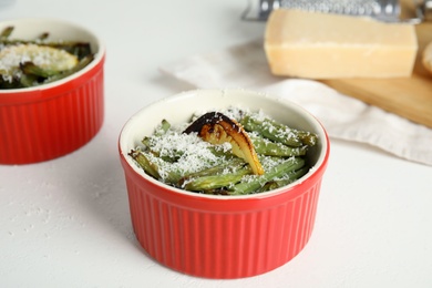 Photo of Delicious baked green beans with lemon and cheese on white table