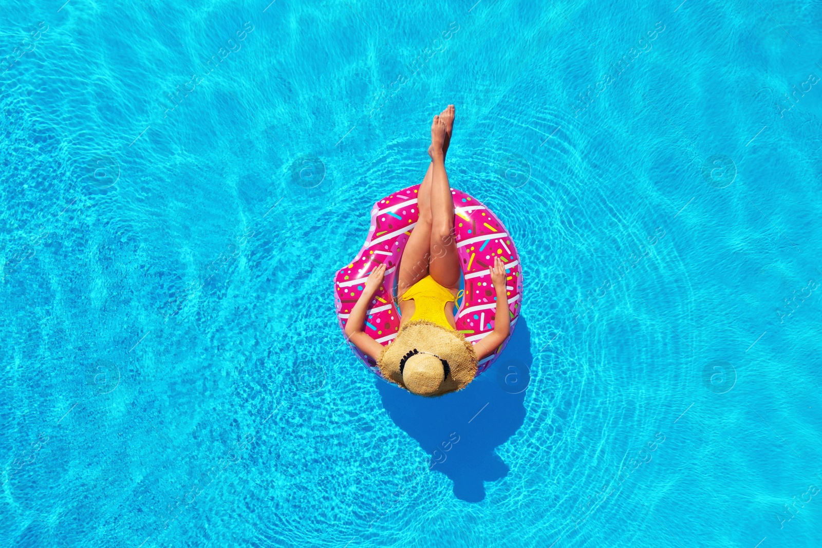 Image of Young woman with inflatable ring in swimming pool, top view