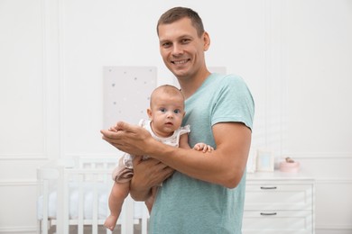 Photo of Happy father with his little baby at home
