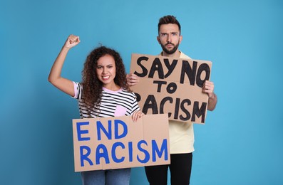 Photo of Protesters demonstrating different anti racism slogans on light blue background. People holding signs with phrases