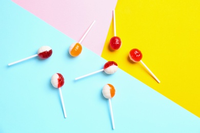 Photo of Flat lay composition with delicious lollipop candies on color background
