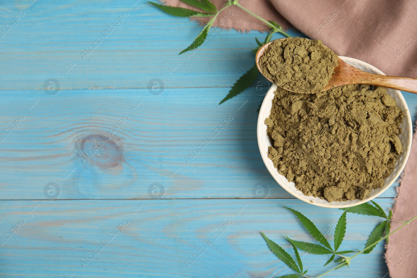 Photo of Hemp protein powder and fresh leaves on light blue wooden table, flat lay. Space for text