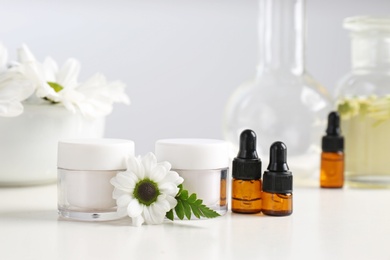 Photo of Skin care products, ingredients and laboratory glassware on table. Dermatology research