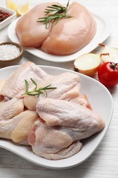 Fresh raw chicken meat and other products on white wooden table