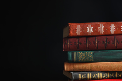 Photo of Collection of different books on dark background. Space for text