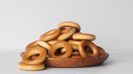 Photo of Plate with tasty dry bagels (sushki) on white textured table