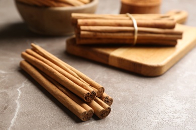 Photo of Aromatic cinnamon sticks on grey table. Space for text