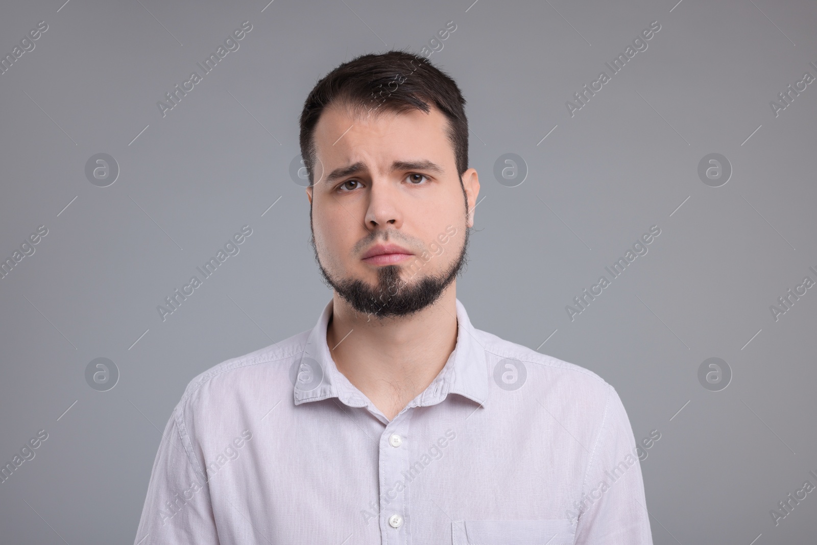 Photo of Portrait of sad man on grey background