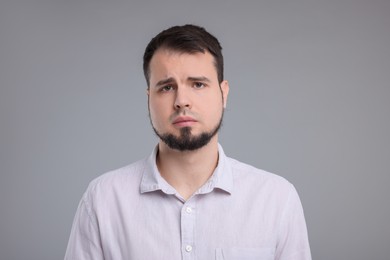 Portrait of sad man on grey background