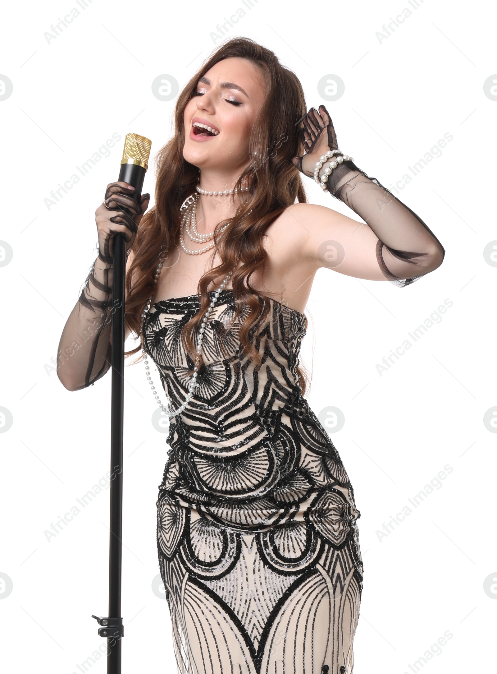 Photo of Beautiful young woman in stylish dress with microphone singing on white background