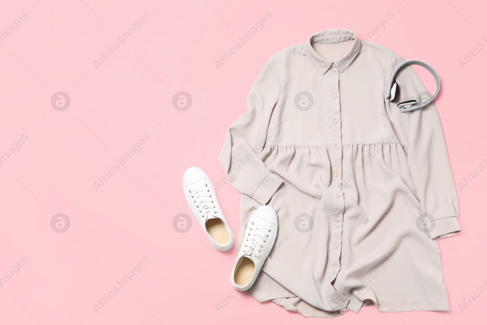 Photo of Stylish grey dress, shoes and headphones on pink background, flat lay. Space for text