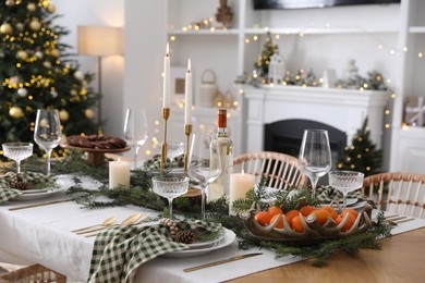 Photo of Christmas table setting with festive decor and dishware in living room