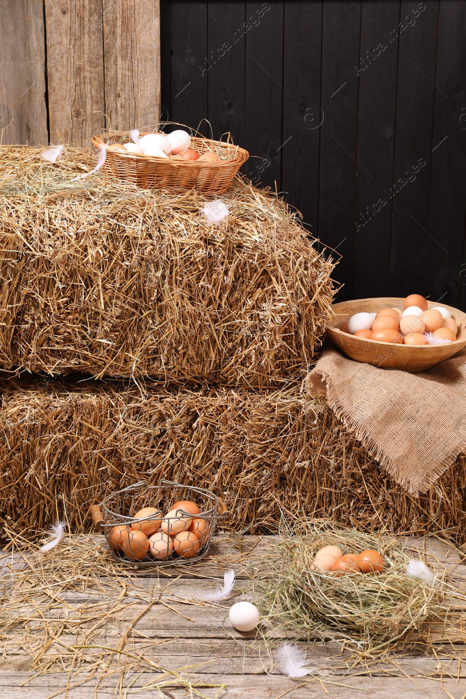 Photo of Fresh chicken eggs and dried straw bales in henhouse