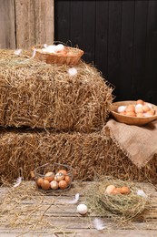 Photo of Fresh chicken eggs and dried straw bales in henhouse