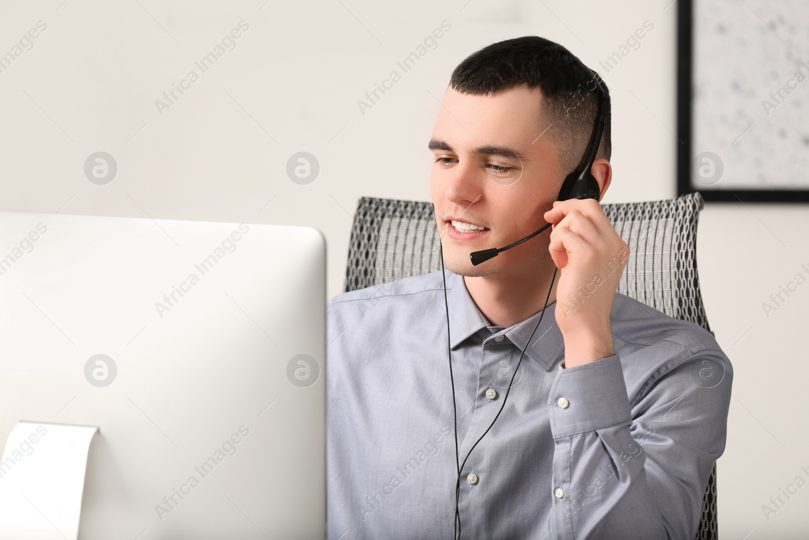 Photo of Hotline operator with headset working in office