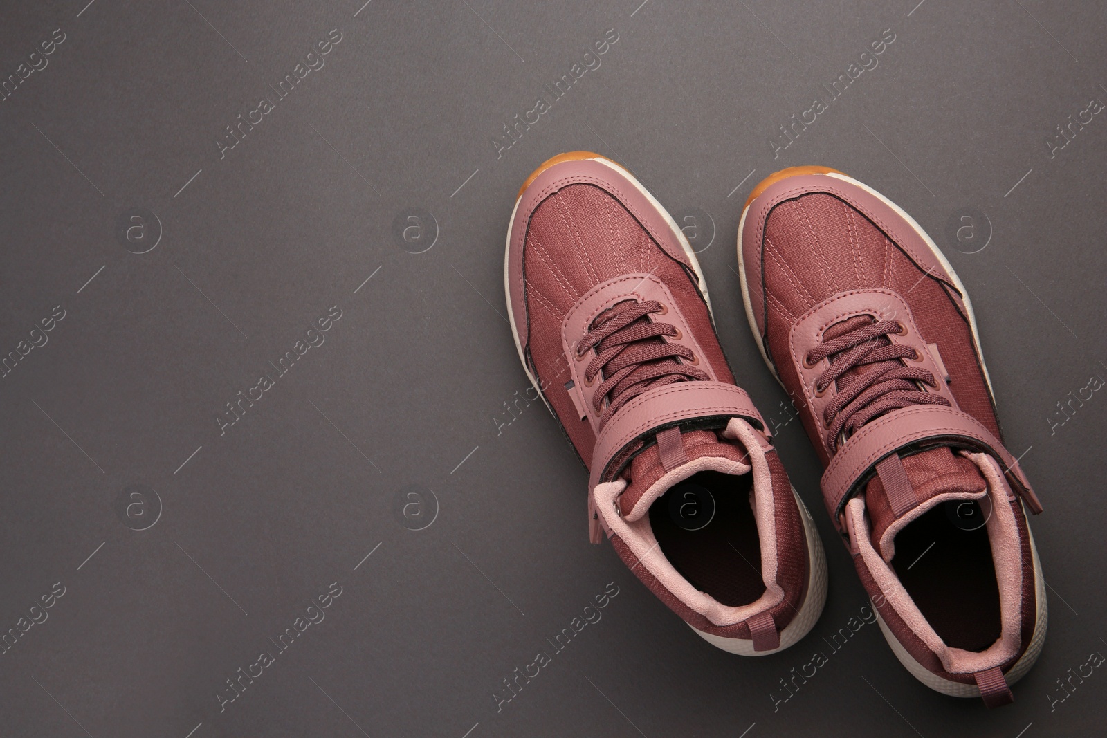 Photo of Pair of stylish kid's sneakers on black background, top view. Space for text