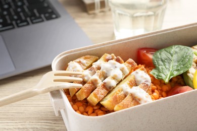 Photo of Healthy products high in vegetable fats near laptop on wooden table, closeup