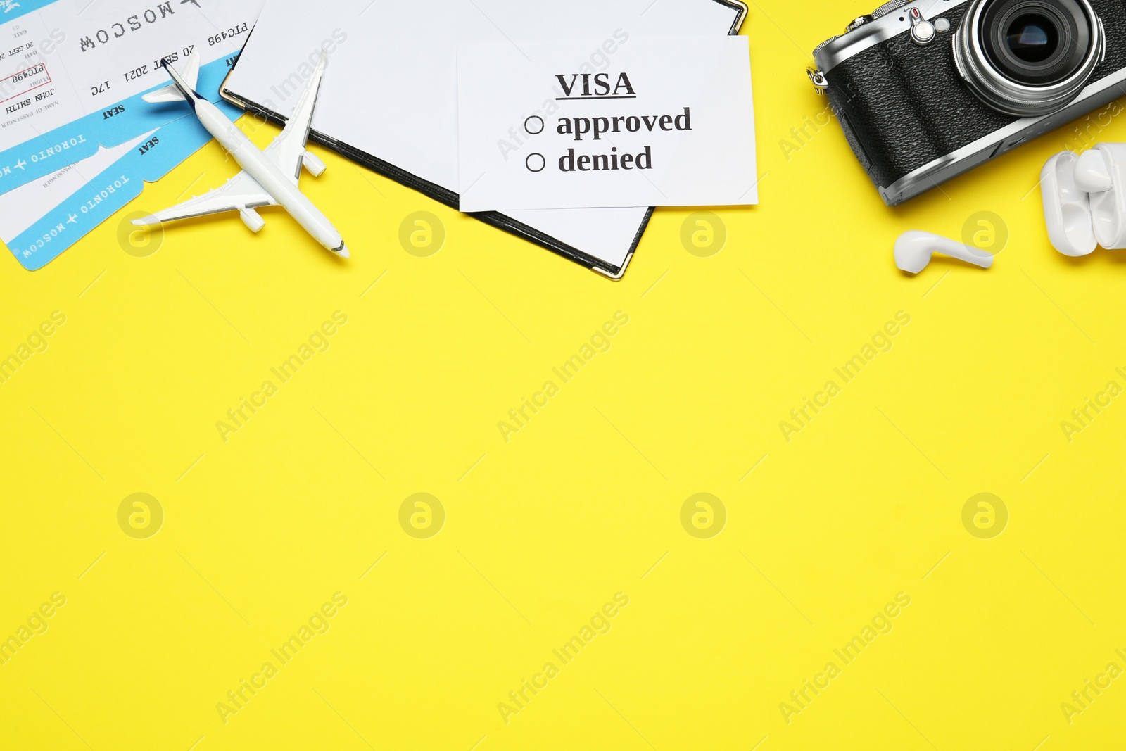 Photo of Flat lay composition with passport, toy plane and tickets on yellow background, space for text. Visa receiving