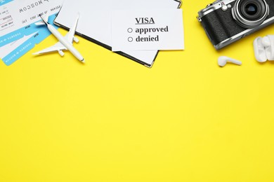 Flat lay composition with passport, toy plane and tickets on yellow background, space for text. Visa receiving