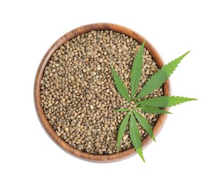 Wooden bowl with hemp seeds and leaves on white background, top view