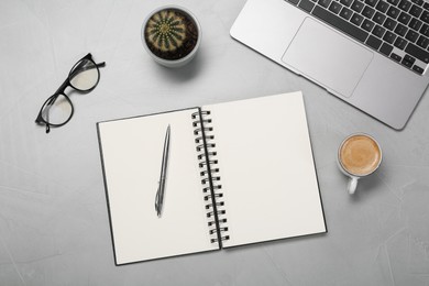 Photo of Flat lay composition with open notebook and laptop on light grey table