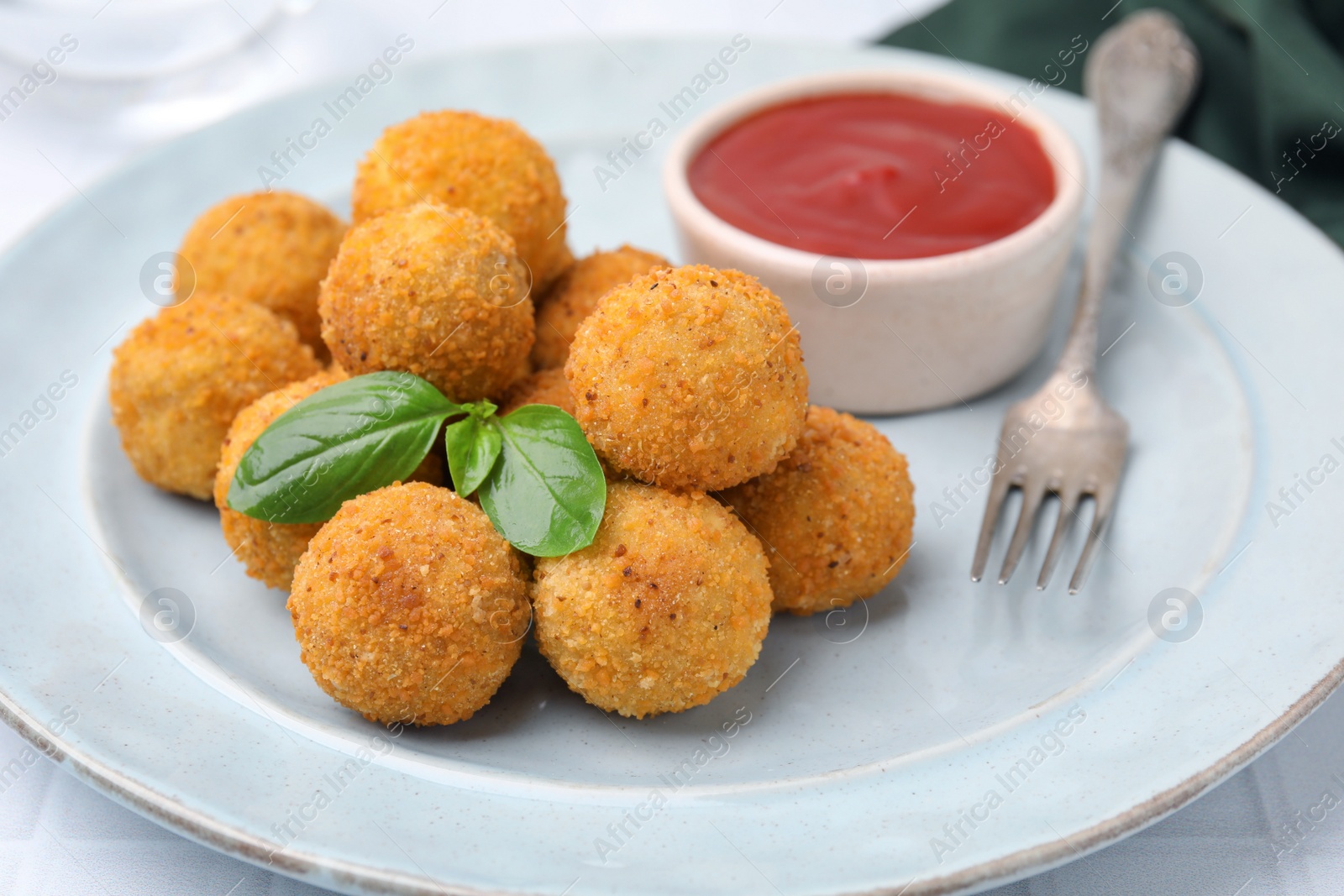 Photo of Delicious fried tofu balls with basil and sauce on plate, closeup