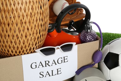 Photo of Box with sign Garage Sale and different stuff against white background, closeup
