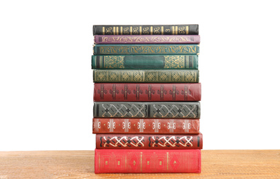 Stack of old vintage books on wooden table against white background