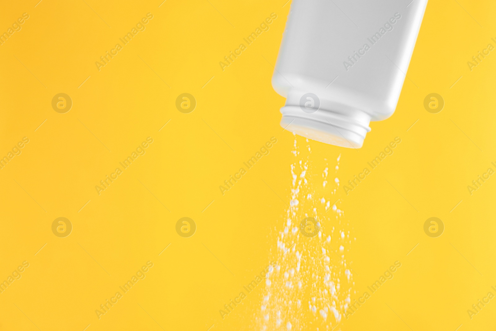 Photo of Scattering of dusting powder on orange background, space for text