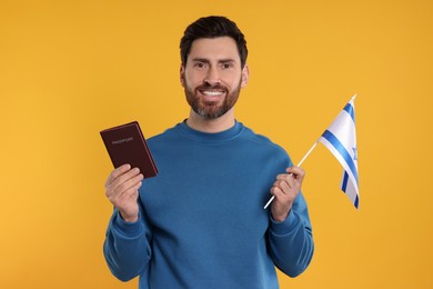 Immigration. Happy man with passport and flag of Israel on orange background