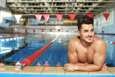 Photo of Young athletic man in swimming pool indoors