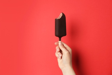 Photo of Woman holding delicious ice cream with chocolate against color background, space for text