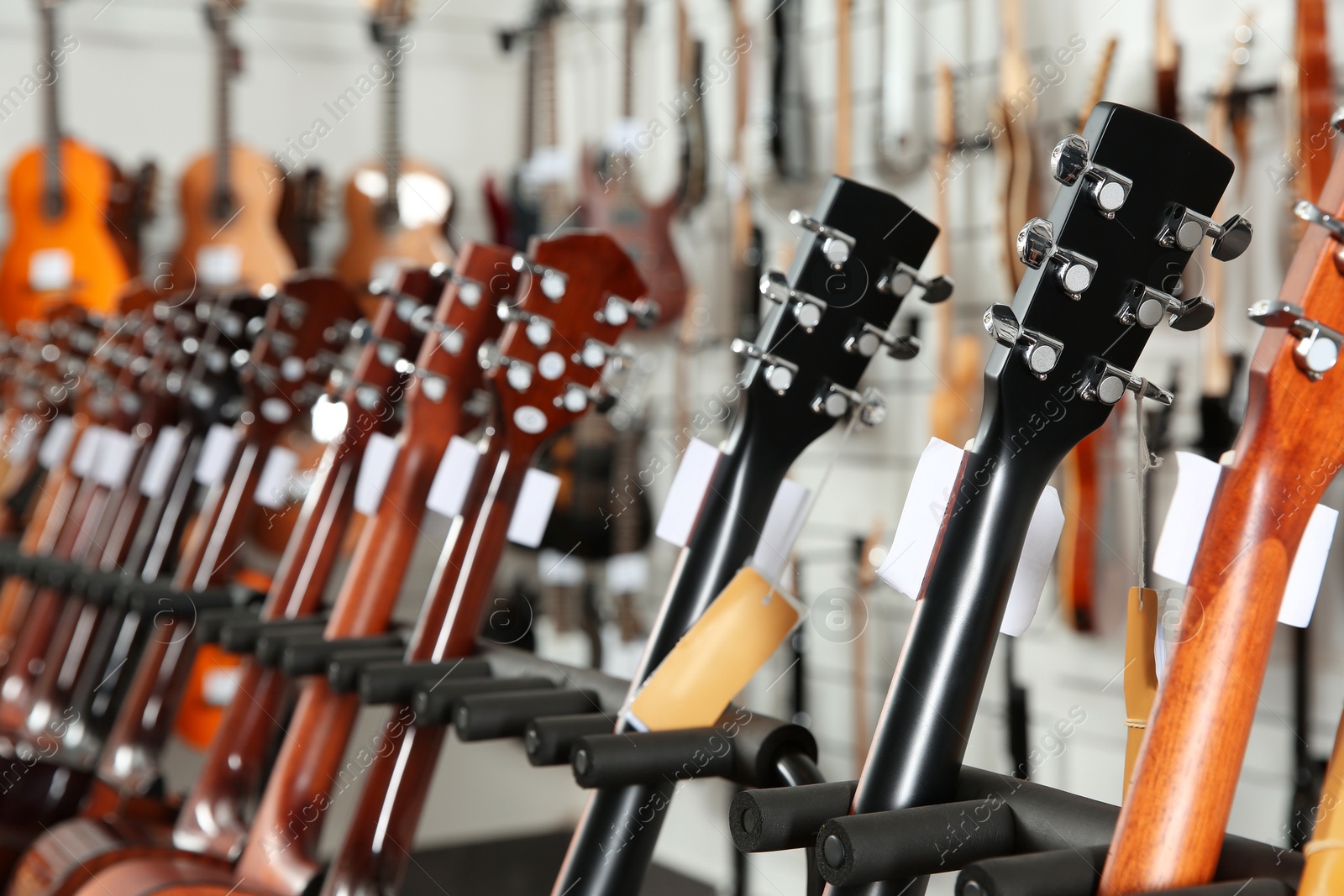 Photo of Row of different guitars in music store, closeup