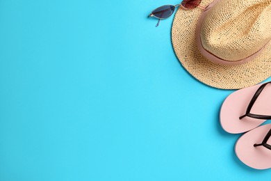 Flat lay composition with straw hat on turquoise background. Space for text