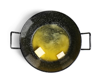 Frying pan with melting butter on white background, top view