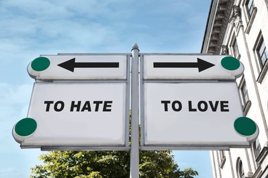 Image of Road signs with different directions - TO HATE or TO LOVE outdoors