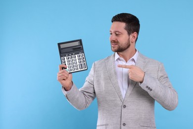 Photo of Happy accountant showing calculator on light blue background. Space for text