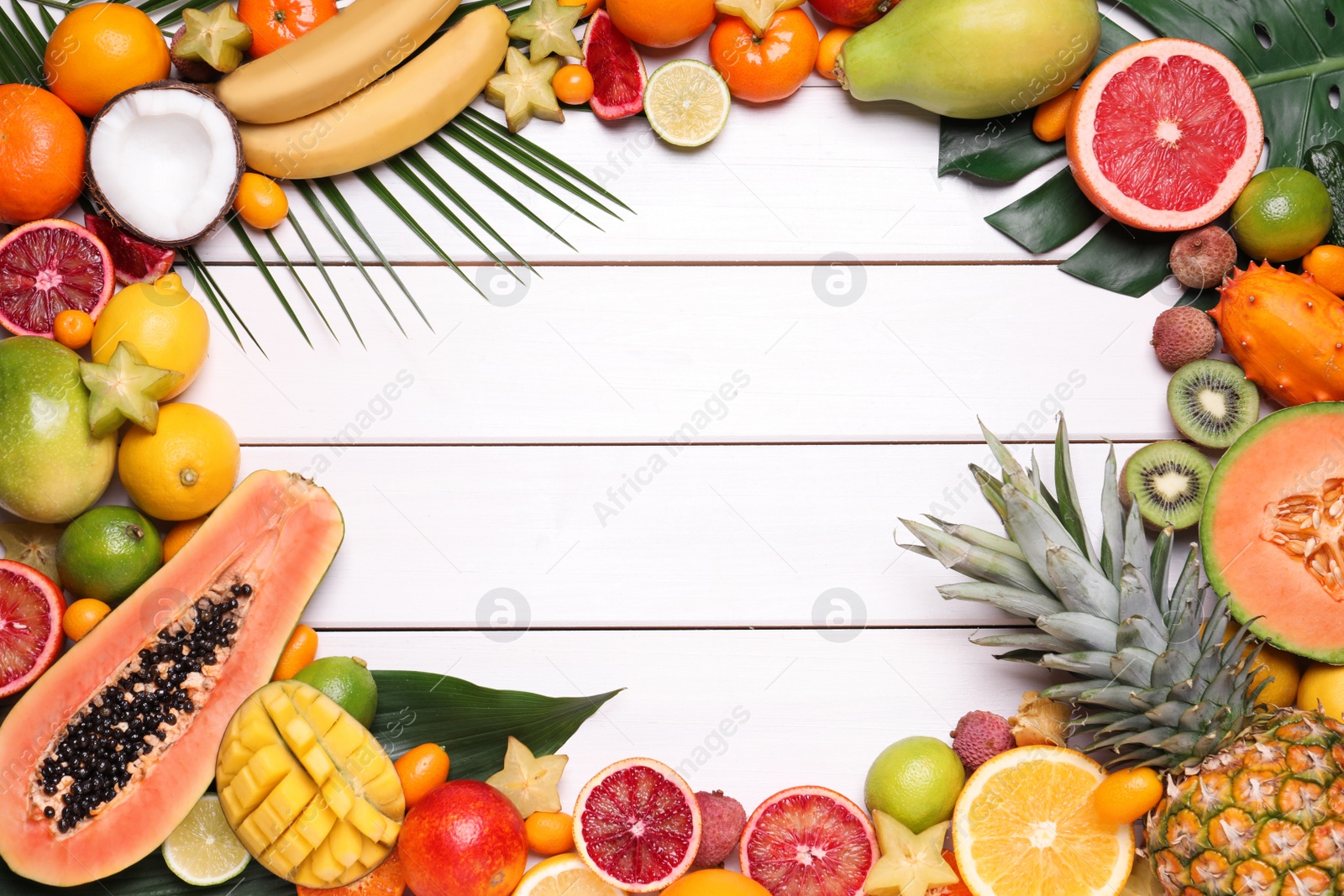 Photo of Frame of different exotic fruits on white wooden background, flat lay. Space for text