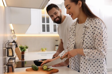 Photo of Happy lovely couple cooking together in kitchen