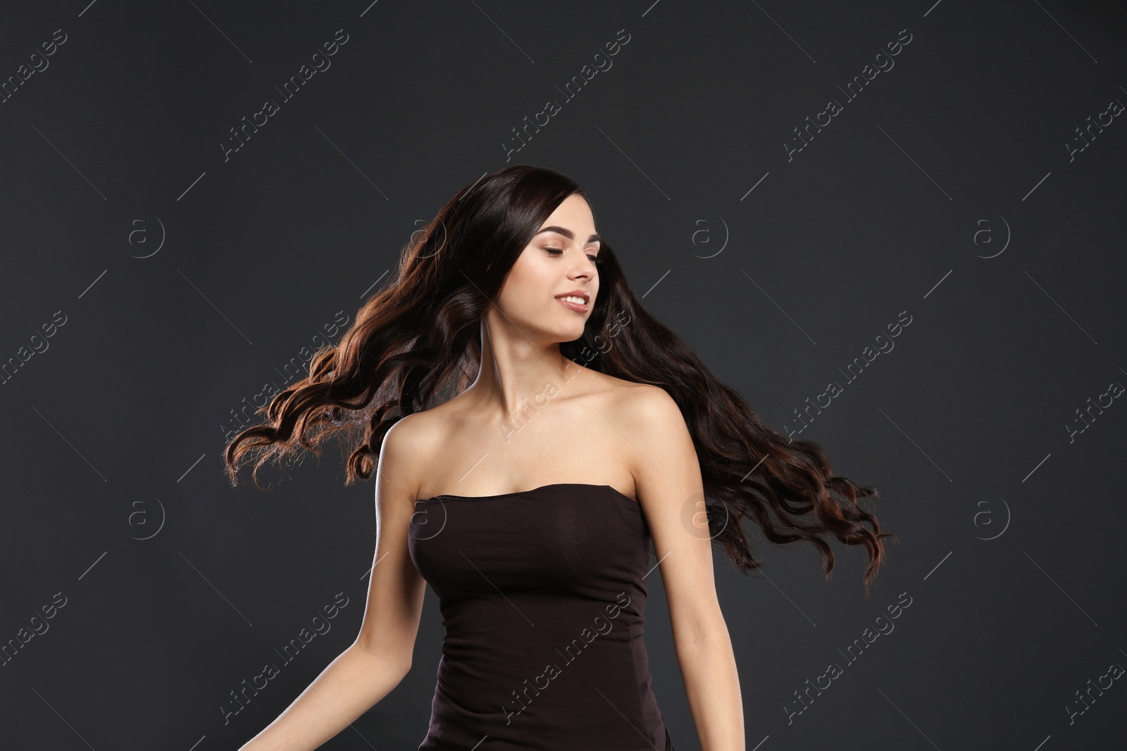 Photo of Portrait of beautiful model with gorgeous curly hair on black background