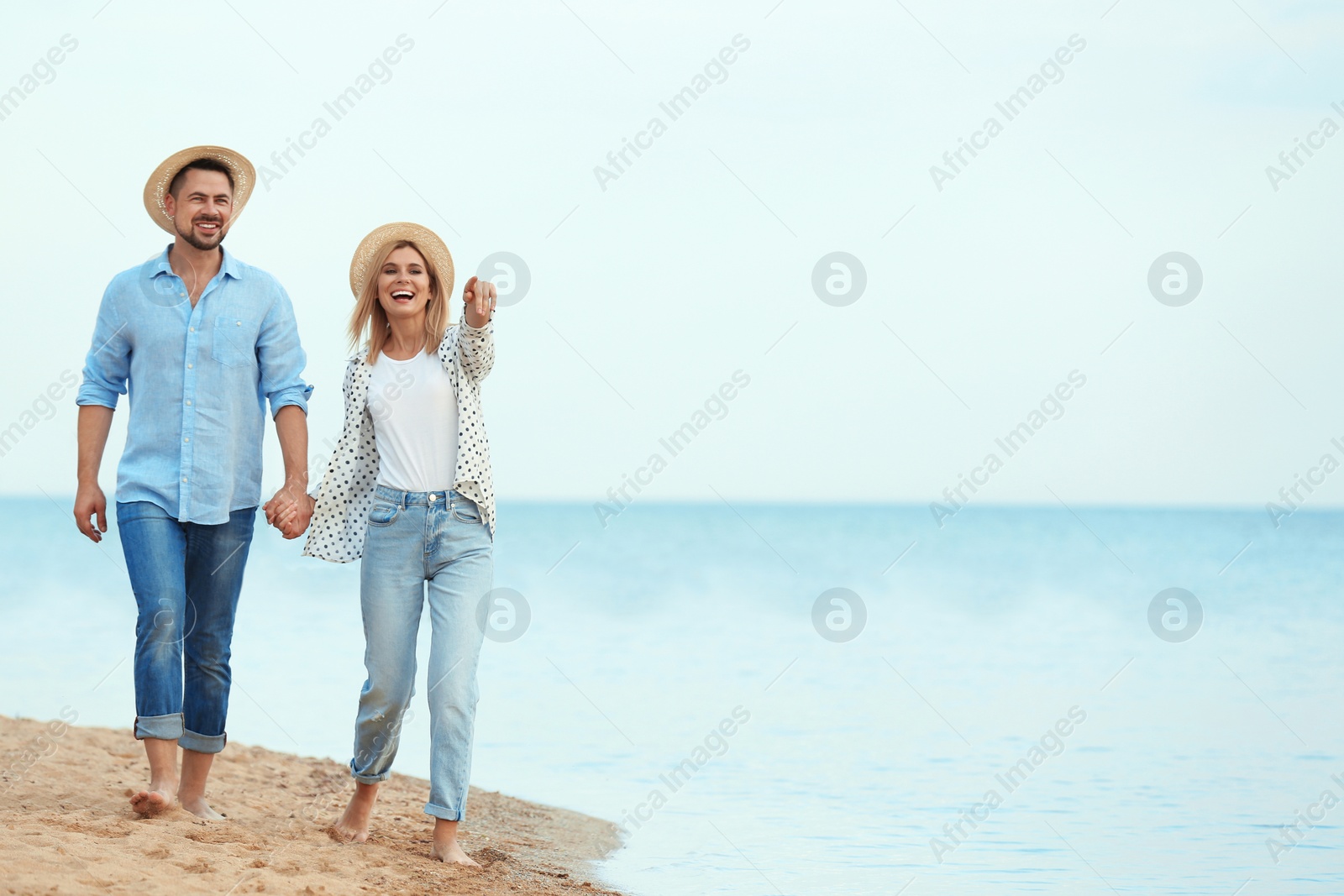 Photo of Happy romantic couple walking on beach, space for text