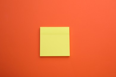 Paper note on orange background, top view