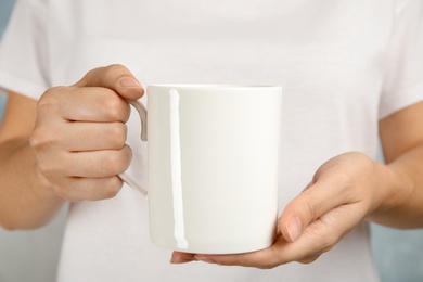 Photo of Woman holding ceramic cup, closeup. Mock up for design