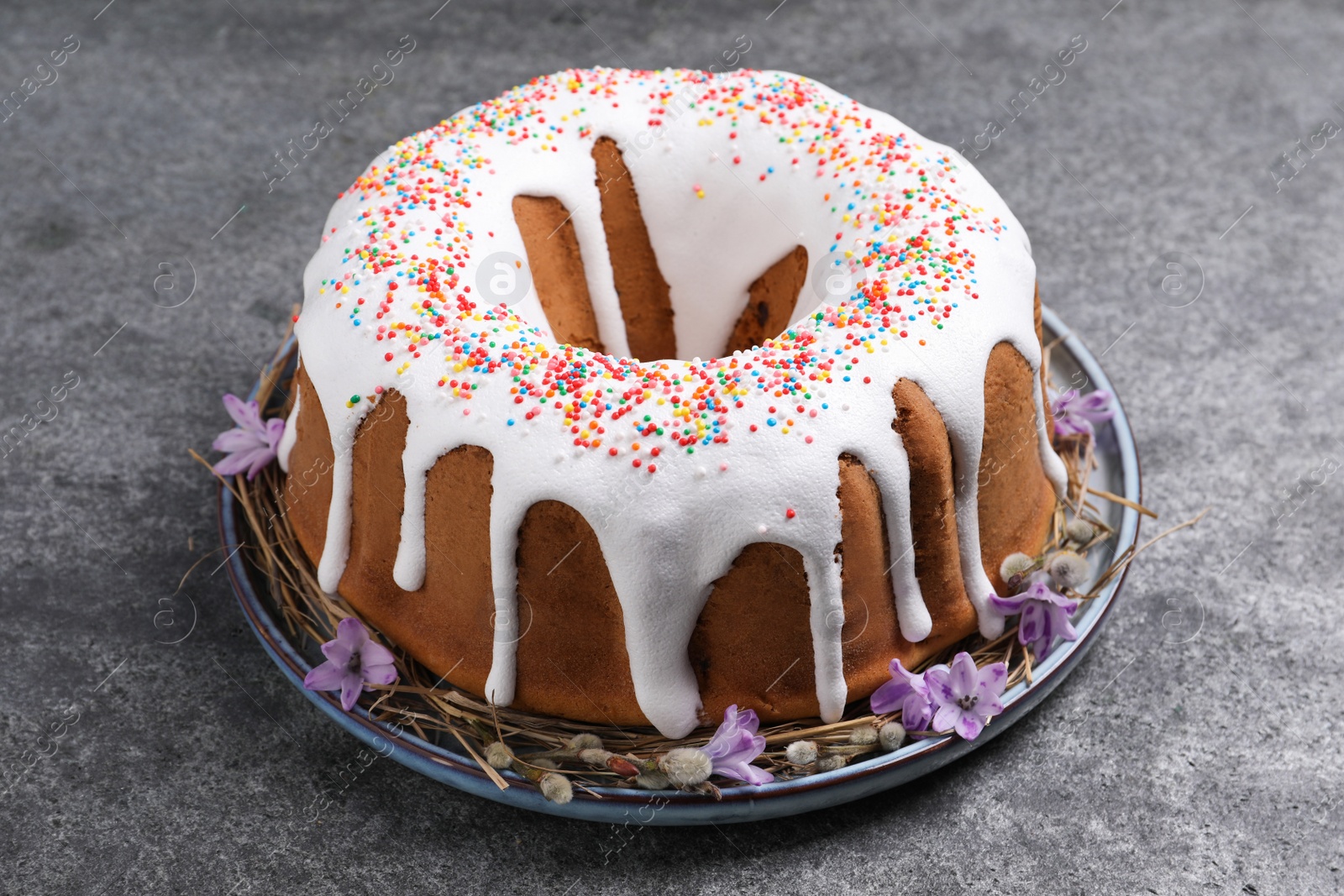 Photo of Glazed Easter cake with sprinkles on grey table