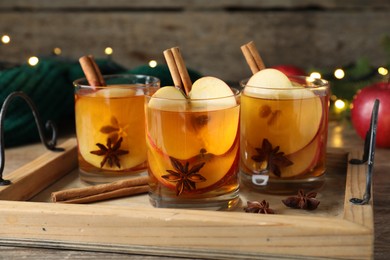 Hot mulled cider, cinnamon and anise on wooden tray