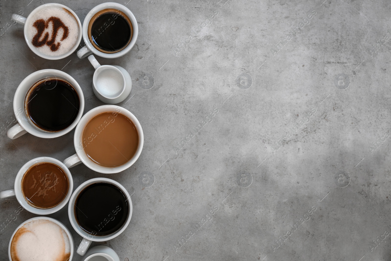 Photo of Cups of fresh aromatic coffee on grey background, top view